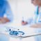 Doctor woman sitting with male patient at the desk